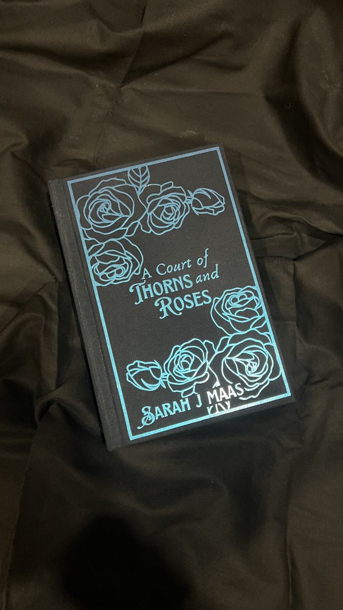 A Court of Thorns and Roses rebind, black cover with teal foil roses